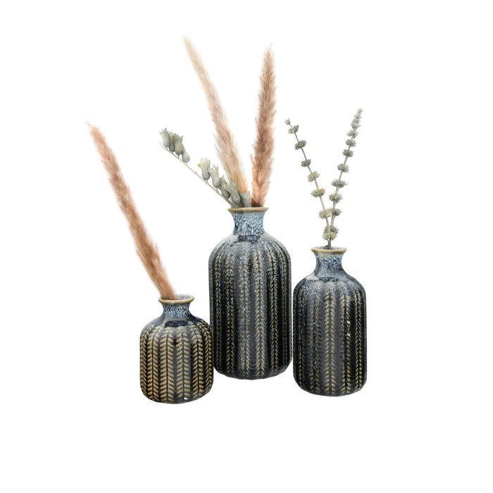 A Blue Stoneware Vase with intricate gold and striped patterns holds dried pampas grass and eucalyptus, arranged on a white background.