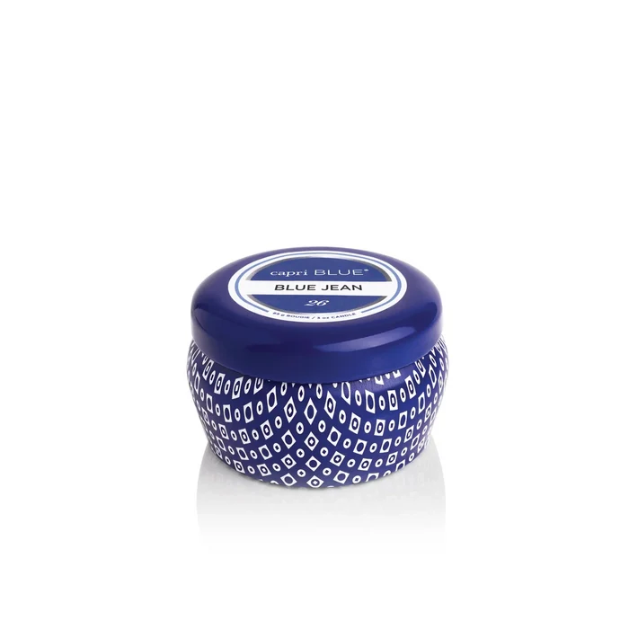 The Capri Blue 3oz Mini Tin candle features a round blue tin labeled Blue Jean with a white geometric design, making it the perfect travel-sized candle, shown against a white background.