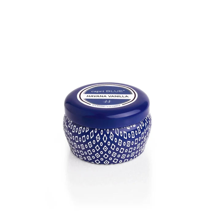 A small, round blue Capri Blue Mini Tin candle featuring a white geometric pattern and matching lid, labeled Havana Vanilla, sits on a plain white background, evoking the signature Capri Blue Jean collection style.