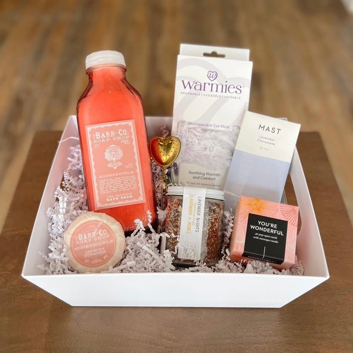Create the perfect Custom Gift Box by Lit Decor and Gift with a bottle of pink liquid, round soap, candle, chocolate bar, microwaveable eye mask, heart-shaped chocolate, and a “You’re Wonderful” packet—an ideal gift for any occasion.