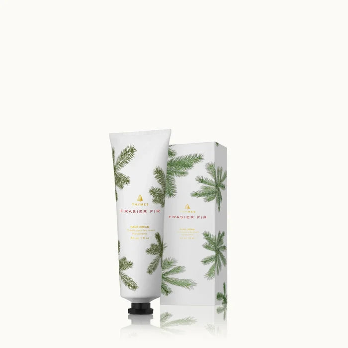 A white tube and matching box of Frasier Fir Home Care Collection hand cream, both featuring green pine branch designs, are displayed against a plain white background.