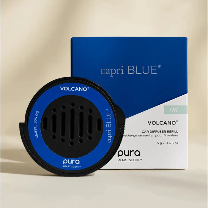 A Pura Car Diffuser Refill is placed in front of its blue and white packaging, showing the product name, scent, and branding details.