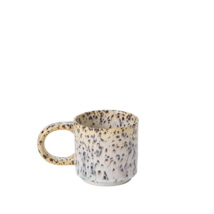 The Starling Mug Collection features a stoneware mug with a wide handle and a brown and cream speckled pattern on white, crafted in an artisanal style and showcased against a plain white backdrop.